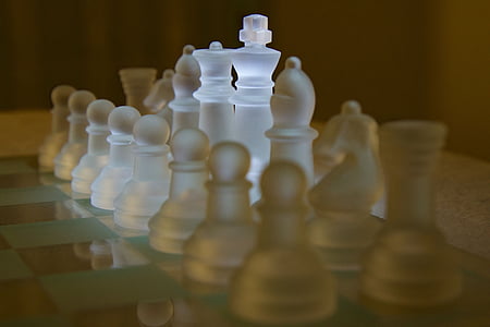 frosted glass chess piece set on chessboard thumbnail