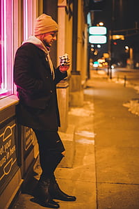 man leaning on gray wall thumbnail