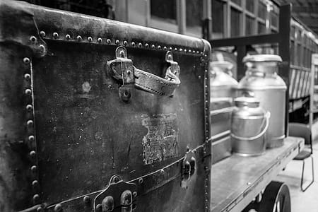 Grayscale Photography of Travel Case With Milk Churns on Trailer thumbnail