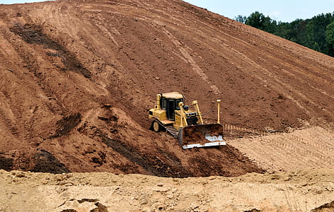 yellow heavy equipment on brown soil thumbnail