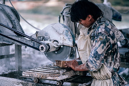 man cutting brown wooden block using industrial saw during daytime thumbnail