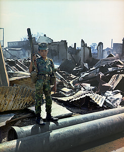 boy holding rifle standing at battleground thumbnail