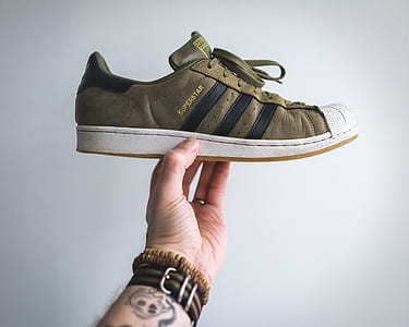 person holding brown low-top shoe thumbnail