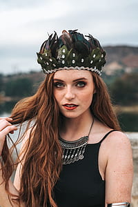 woman in black spaghetti strap top wearing feather crown during daytime thumbnail