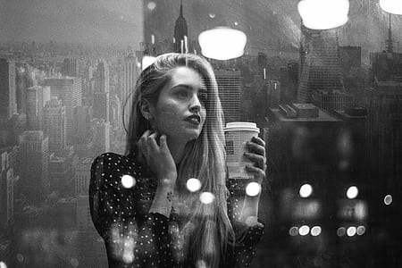 grayscale photo of woman holding plastic disposable cup thumbnail