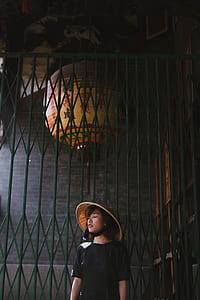 woman wearing brown hat beside green metal scissors door thumbnail