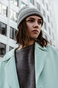woman standing beside grey concrete building thumbnail