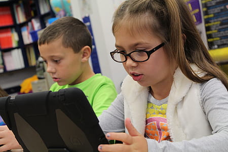 girl in gray top holing tablet thumbnail