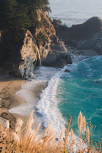 rock formation near seashore and body of water at daytime thumbnail