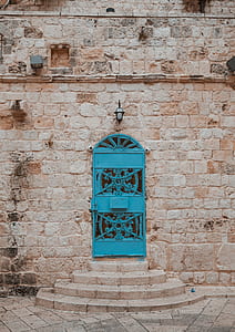 blue metal door on grey brick building thumbnail