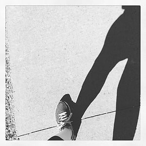 grayscale photo of person walking on sidewalk thumbnail