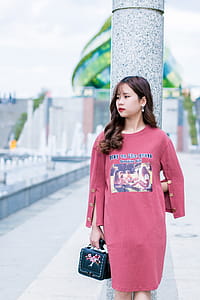 Woman Wearing Pink Crew-neck Long-sleeved Dress Standing Beside Gray Marble Pedestal Column thumbnail