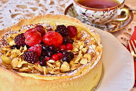 white plate of round cake with fruit toppings thumbnail