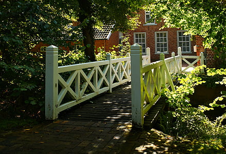 white and brown wooden bridge in front of brown house thumbnail