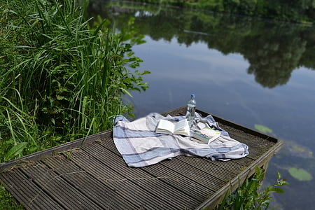 bottle and mat on black dock platform near body of water thumbnail
