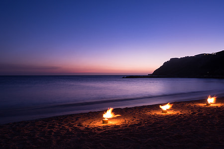 three bonfires near body of water thumbnail