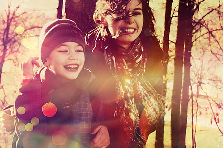 woman and child standing near trees photograph thumbnail