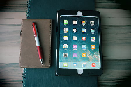 white iPad with black case on green notebook thumbnail