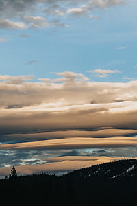 silhouette photo of mountain under the cloudy sky thumbnail