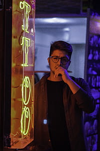 man standing beside tattoo neon sign thumbnail