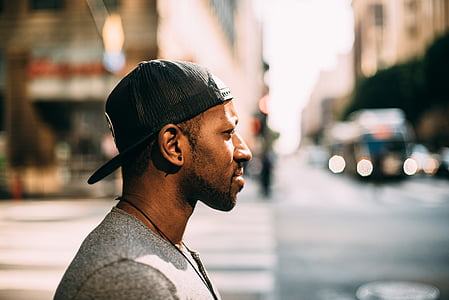 man wearing black snapback standing on street thumbnail