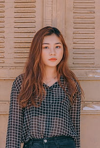 Woman Wearing Blouse and Denim Bottoms Standing Against the Wall thumbnail