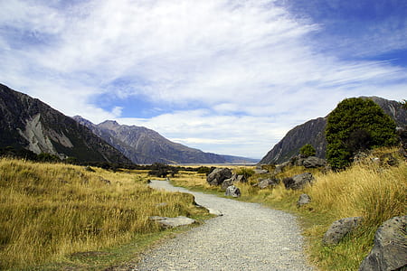 landscape photography of mountains, grass, and road thumbnail