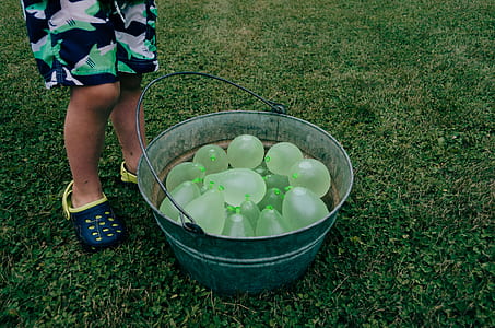child standing beside blue metal container thumbnail