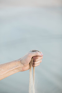 sand flowing on person's hand thumbnail