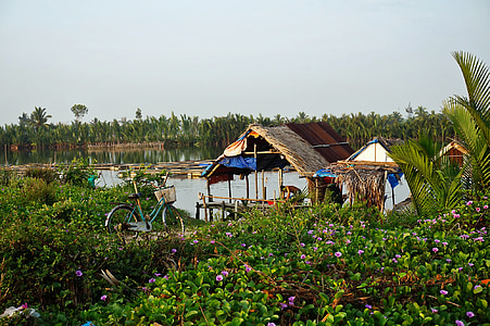 cottage near flower garden and body of water thumbnail