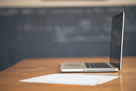 black and grey laptop on brown wooden table thumbnail