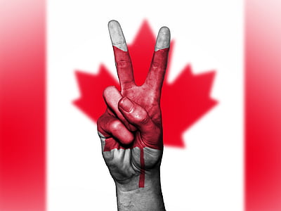 person's right hand forming peace symbol with Canada flag background thumbnail