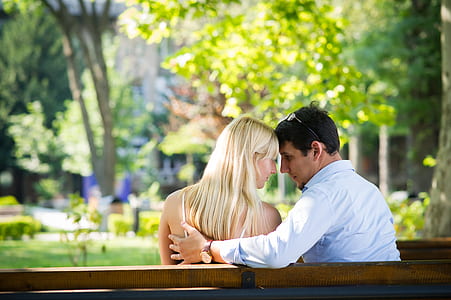 woman and man sitting on bench during daytime thumbnail