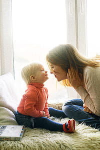 Woman And Child Sitting On Fur Covered Bed thumbnail