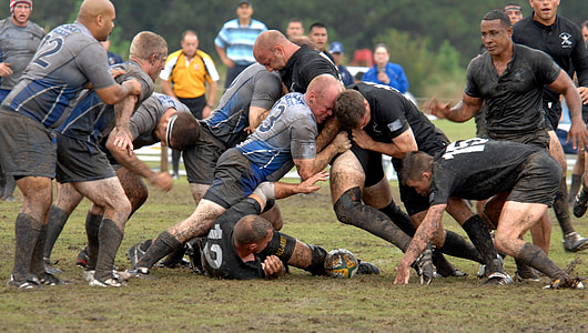 group of men playing rugby on mud field at daytime thumbnail