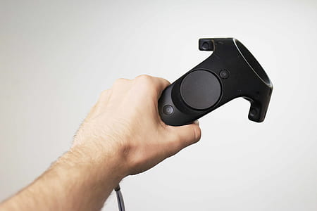 person holding black game controller thumbnail