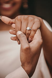 person holding hand of woman with ring thumbnail