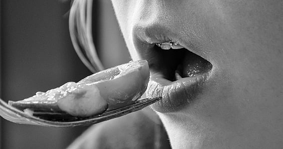 grayscale photography of woman eating thumbnail