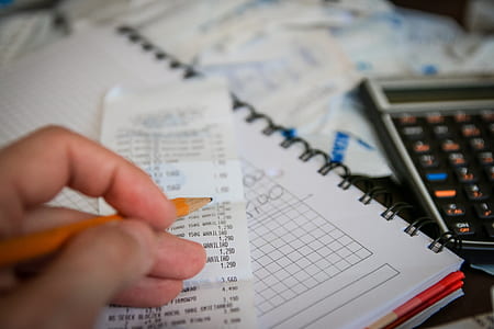 person holding pencil and receipt paper thumbnail