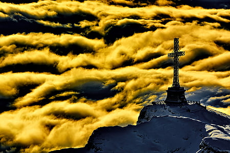 cross statue on top of white mountain during day time thumbnail