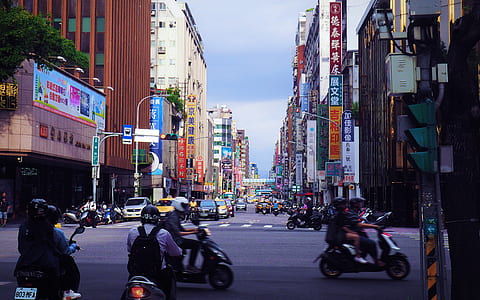 people riding motorcycle on road near buildings thumbnail