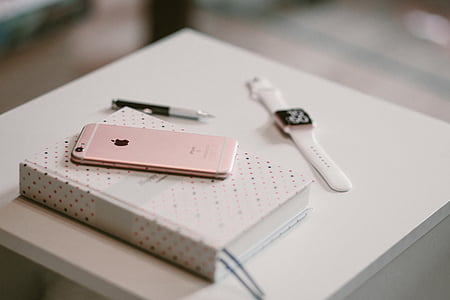 rose gold iPhone 6s on white book near gold aluminum case Apple Watch thumbnail