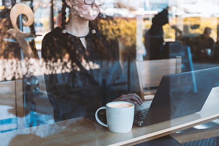 Girl studying on laptop in bar by the window thumbnail