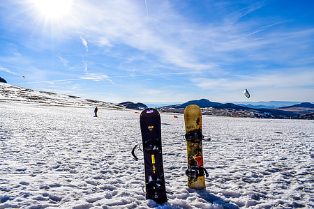 two yellow and black snowboards stuck on snows thumbnail