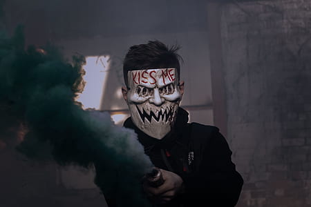 shallow focus photography of man in black pullover hoodie wearing white mask thumbnail
