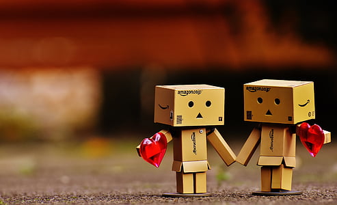 selective focus photo of two cardboard couples holding hearts thumbnail