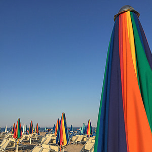 rainbow-color patio umbrellas on beach thumbnail