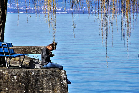 woman sitting in front of body of water thumbnail