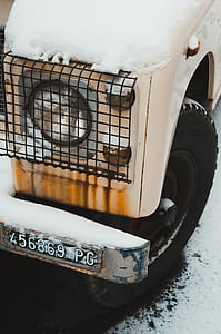 classic white vehicle parked on snow filled road thumbnail