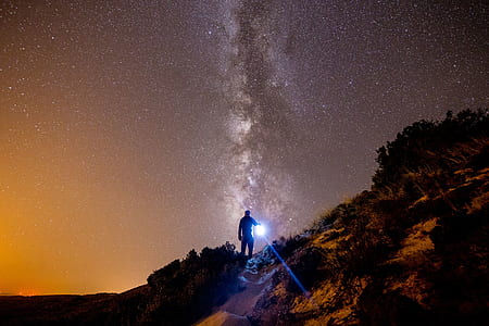 man walking on mountain during night time thumbnail